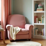 Coin lecture enfant avec fauteuil en velours rose poudré, étagères de livres colorés et tapis en laine dans une chambre décorée en tons pastels