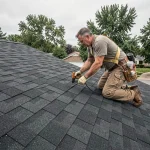 Couvreur posant des shingles bitumineux sur une toiture en pente de maison individuelle