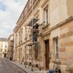 Équipe de ravalement de façade travaillant sur un immeuble en pierre de taille de style bordelais en Gironde