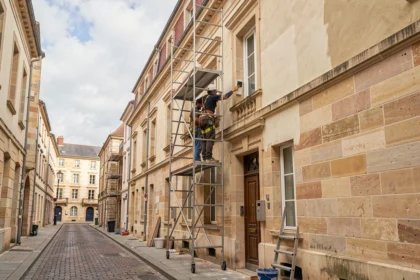 Équipe de ravalement de façade travaillant sur un immeuble en pierre de taille de style bordelais en Gironde