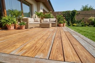 Terrasse en bois exotique teck avec mobilier de jardin et plantes vertes dans un jardin résidentiel